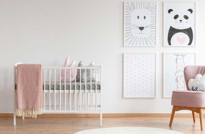 Bir beşiğin ve tabloların yer aldığı bir bebek odası
