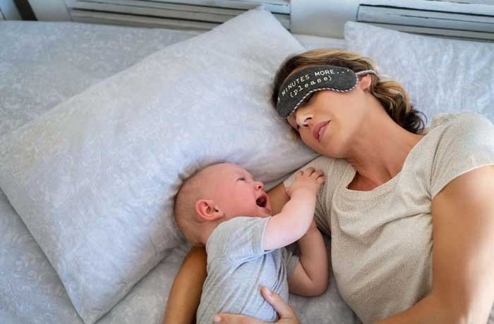 Bebeği ile uyuyan bir kadın