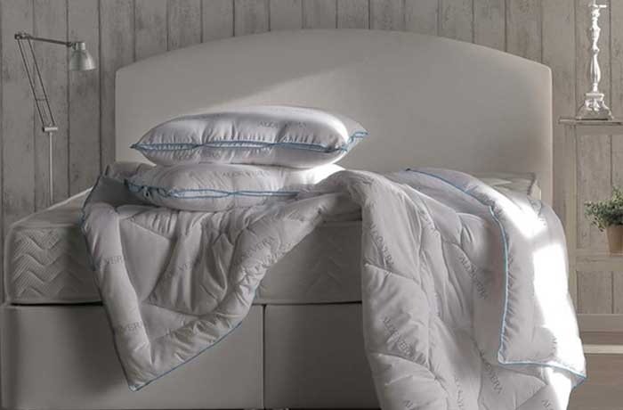 Yatağın üzerinde bulunan iki yastık ve yorgan