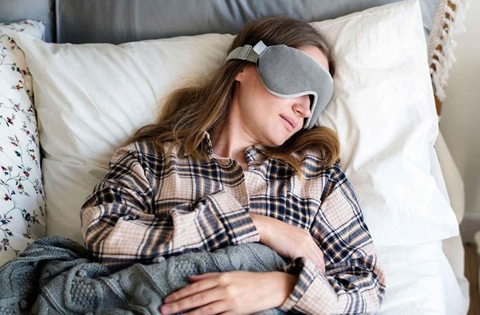 Göz bandı ile uyuyan bir kadın